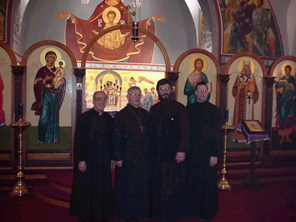 Clergy pose for a picture in front of iconastasis.