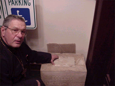 Father Harrison Examines Compartment.