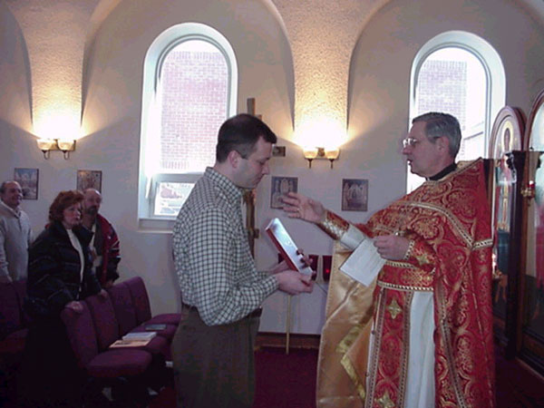 Dan receives his icon from Father Harrison.