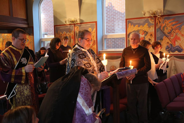 Father Paul and Deacon 
prepare for the readings of the Passion Gospels .