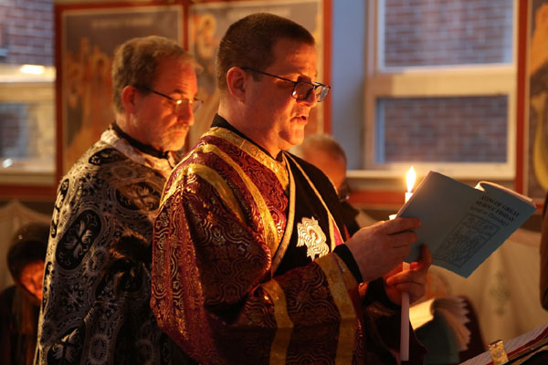 Father Paul and Deacon 
prepare for the readings of the Passion Gospels .